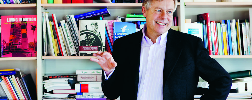 Rolf Wolff framför en bokhylla i rektorsrummet på Handelshögskolan.