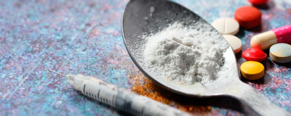 Bilden visar narkotika i form av tabletter och en spruta.