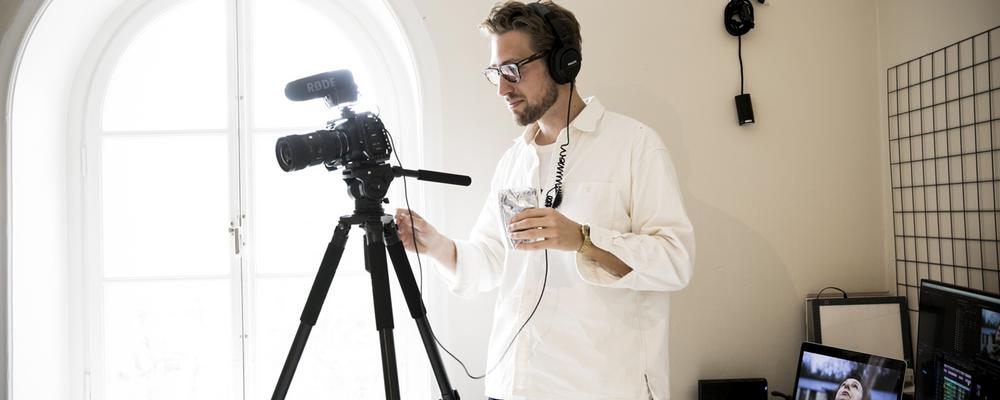 Sebastian Johansson Micci tittar in i sin filmkamera.