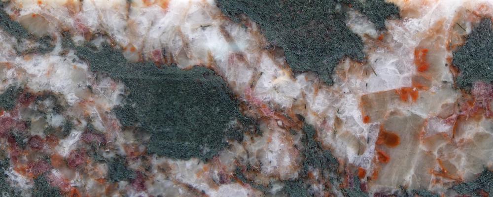 Norra Kärr innehåller ovanliga bergarter som är rika på sällsynta jordartsmetaller, vilka är inkorporerade i det sällsynta röda mineralet eudialyt (nere till vänster).