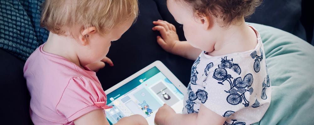 Two small children playing with a tablet