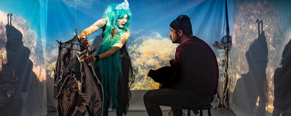 Två personer i ett rum upplyst av en projektor