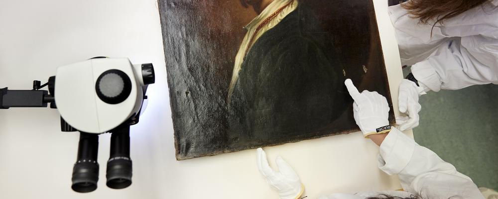 Students examining an old painting.