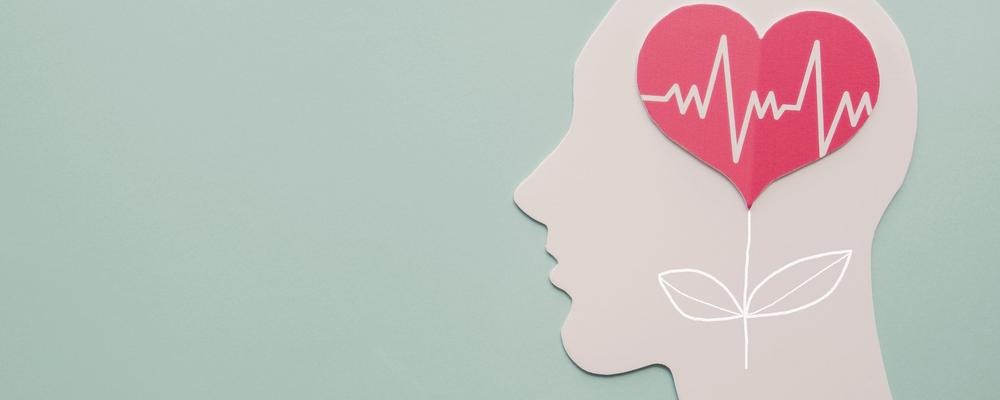 Bild på en pappersfirgur i profil där hjärnan innehåller ett träd med ett hjärta.