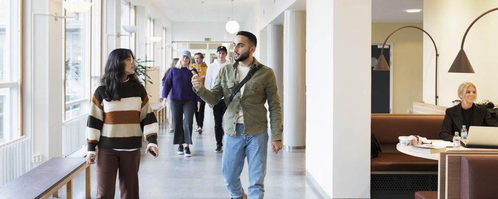 Några studenter går i en korridor på Handelshögskolan