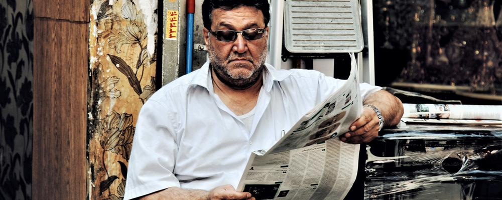 En man läser en dagstidning.