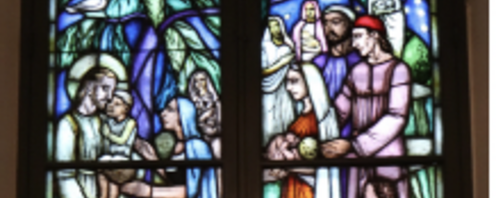 Bilden föreställer ett kyrkfönster med en glasmålning