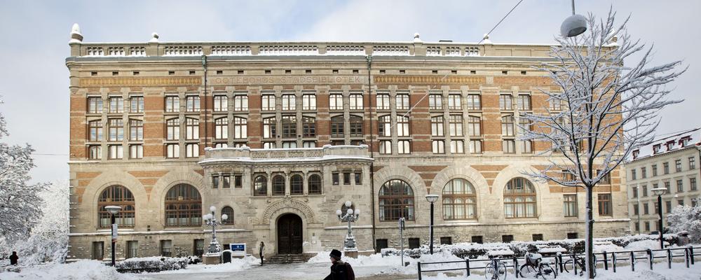 Bibliotek i Göteborg på vintern med en person som går i förgrunden
