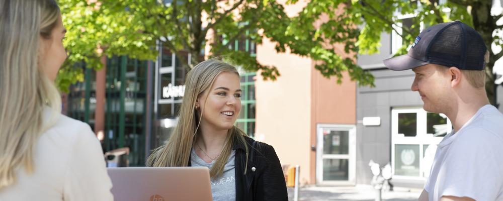 student med laptop framför byggnaden "kuggen" på lindholmen
