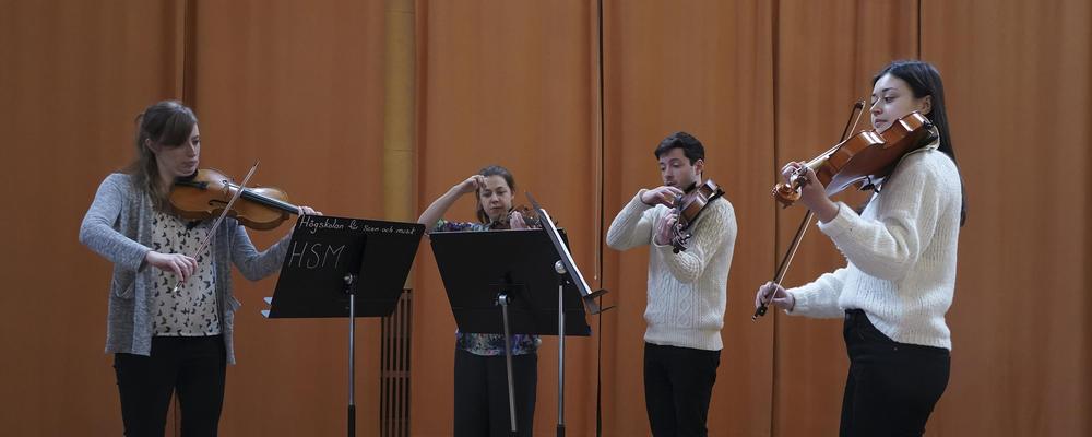 Fyra personer spelar fiol