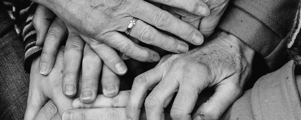 äldre människors händer som bildar ett nätverk