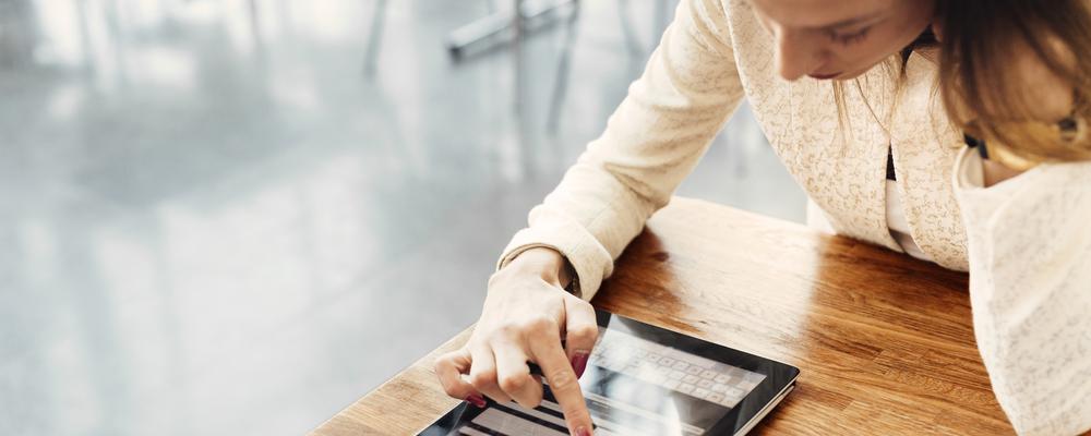 Kvinna läser på en platta.