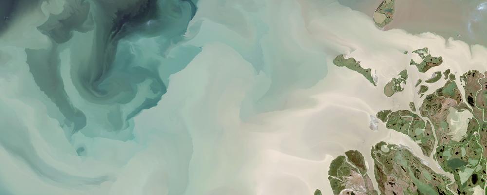 aerial photo of mackenzie river in alaska emptying into sea