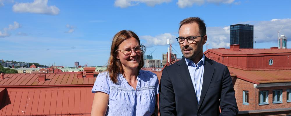 Åsa Löfgren och Carl Hammer står på Handelshögskolans terrass. Bakom dem ses hustak.