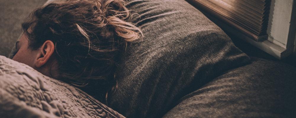 Kvinna sover i en säng.