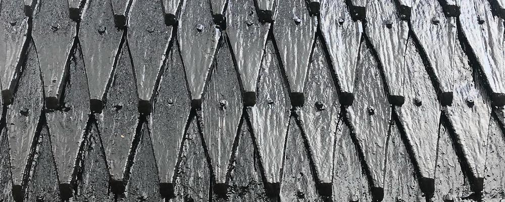 Bilden visar ett svart tjärat spåntak