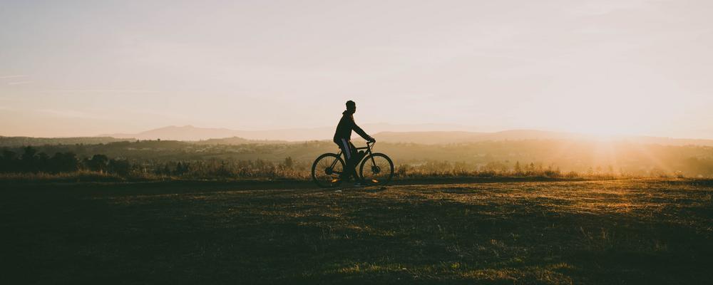 image of person biking across a field
