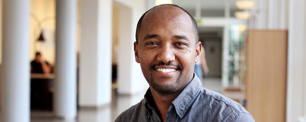 Portrait of Tewodros Tesemmas in a bright corridor in the School f Business, Economics and Law