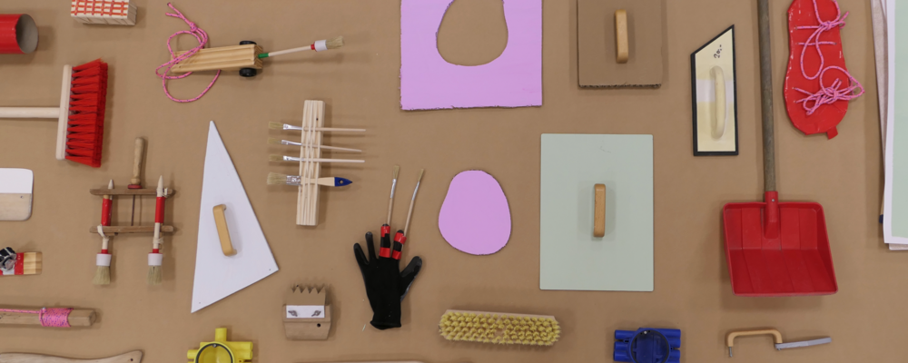 Olika material och verktyg utspridda på en kartongskiva.