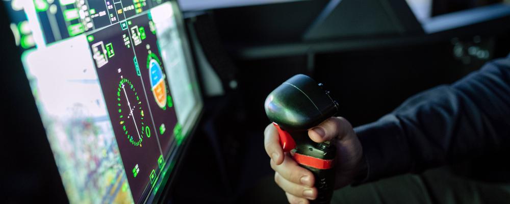 Hand som styr båt med hjälp av en joystick