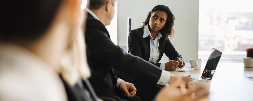 Personer framför en dator på ett kontor.