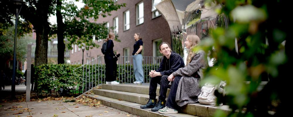 Students sitting outside a brick building