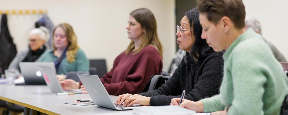 Studenter på masterprogram i didaktik i klassrum med datorer och anteckningsblock