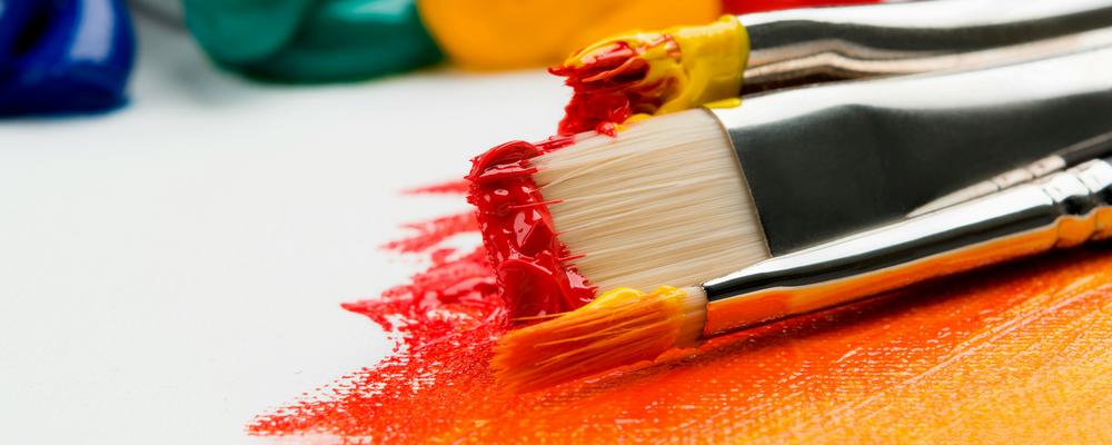 Tre silverfärgpenslar på vit textilfoto