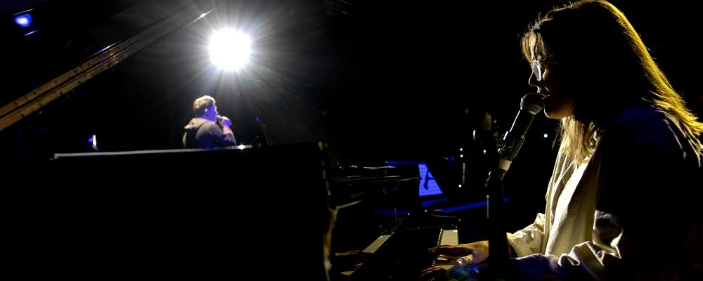 One person at the piano, another in the background