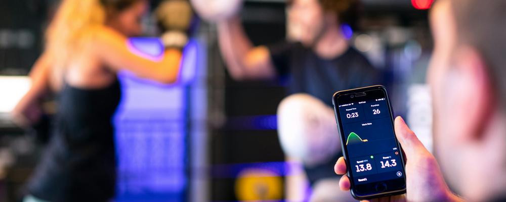 Man övervakar två personer som boxas via en app.