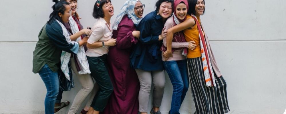 Bilden visar sju kvinnor som skrattar tillsammans