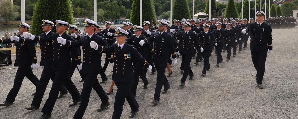 Yrkesofficerare i uniform som marscherar