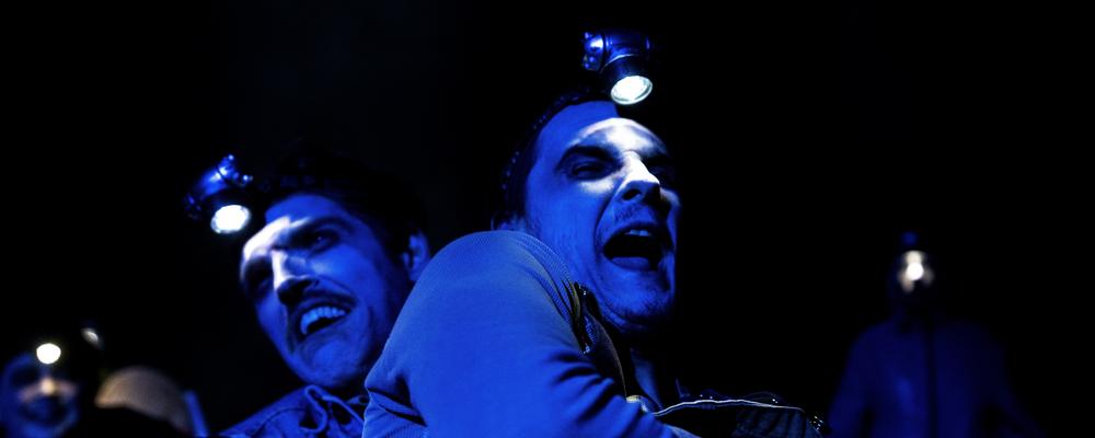 Två personer belysta med blått scenljus