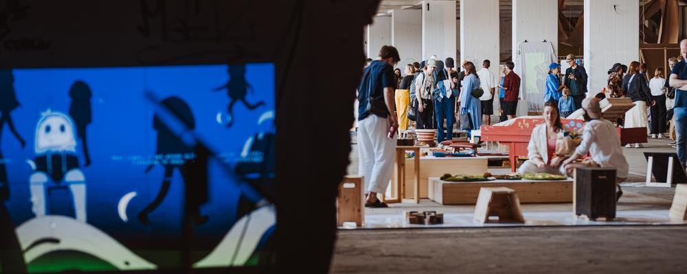 En mörk utställningsmiljö med besökare i bakgrunden