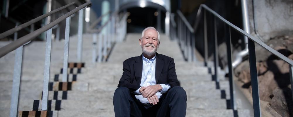Bild på Jörgen Isgaard sitter i en brant stentrappa som leder upp till Sahlgrenska akademin. 