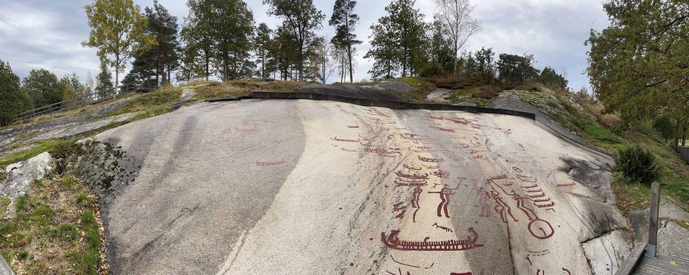 Sten häll med hällristningar, båtar ifyllda med röd färg