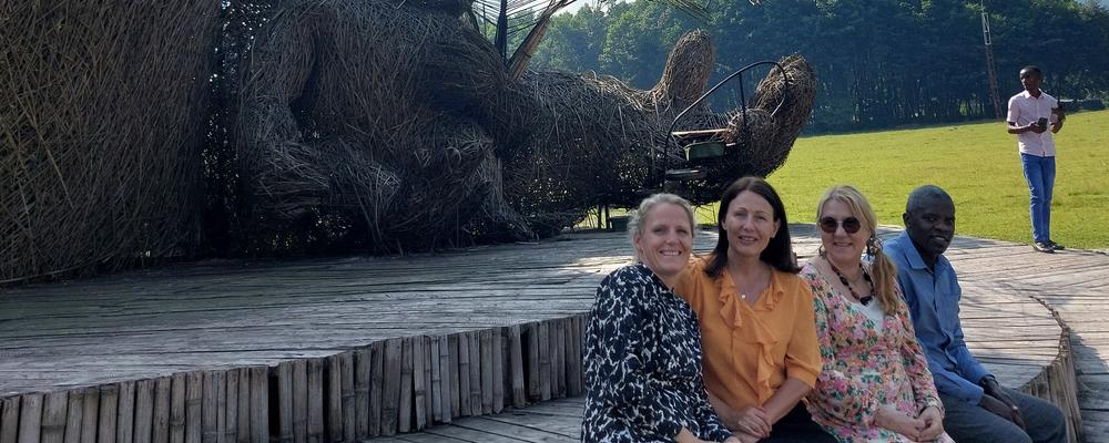 fyra forskare sitter vid ett monument i Rwanda 