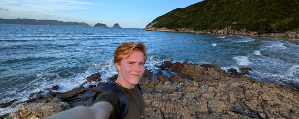 En person på hike med hav och berg i bakgrunden