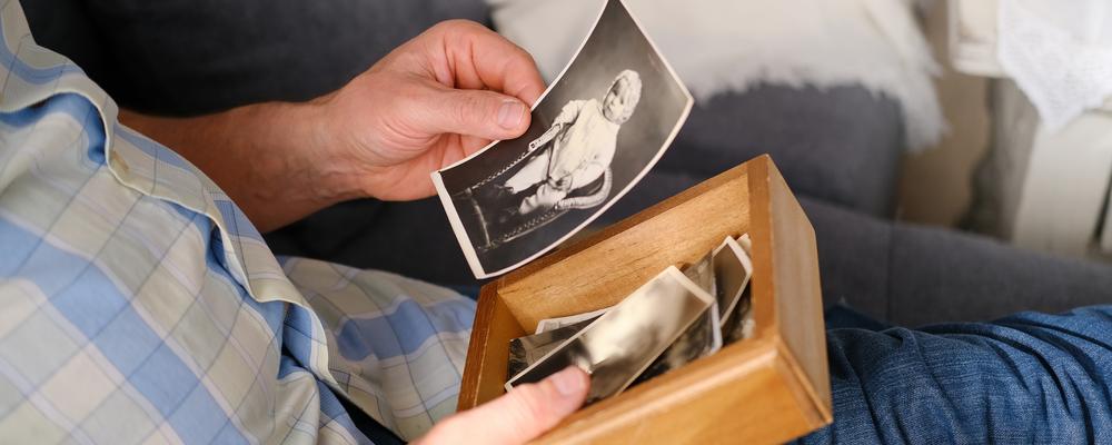 man med svartvita foton i knät