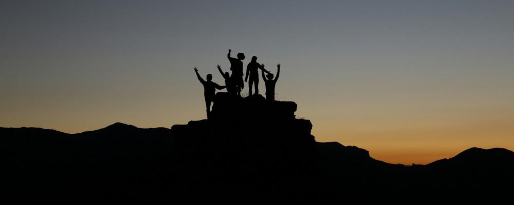Människor på ett berg i solnedgång