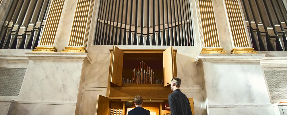 Two persons in front of a church organ