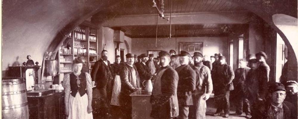 Interiörbild från "Krog" med okänd adress. Av takvalv och fönsternischer att döma kan det möjligen vara en utskänkningslokal innanför vallgraven. Fotot är troligen från 1880-1890-tal och beskrivs som en ölhall med bardisk, flaskor på hyllorna, öltunna. På