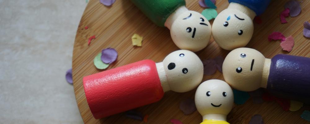 trädockor som visar olika miner för att illustrera olika känslor hos medarbetare