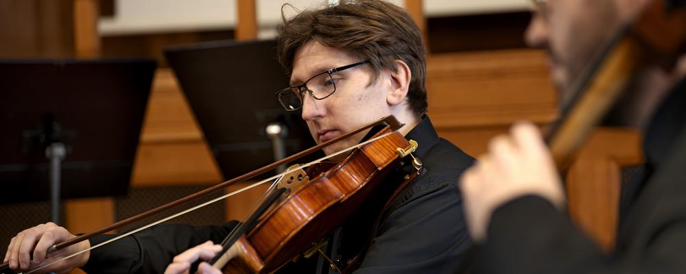 Two persons playing bowed string instruments