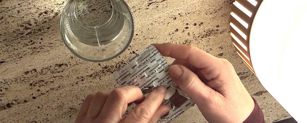 ett glas vatten och tabletter (illustration av antibiotikaresistens)