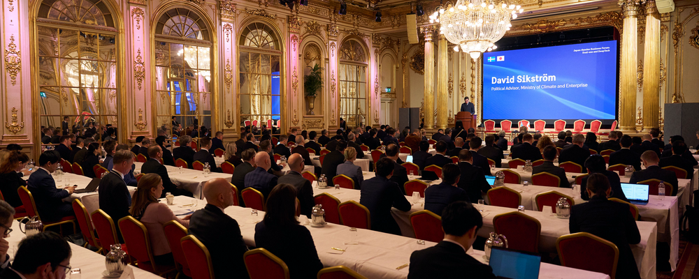 Participants in a conference sit in a large conference room