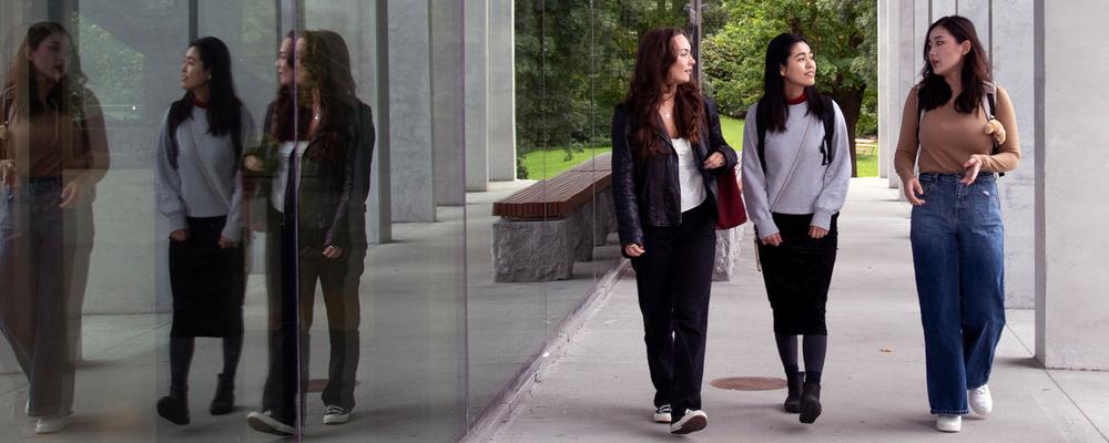 four students walking along a corridor
