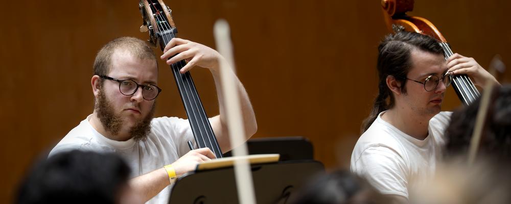 Two persons playing double bass