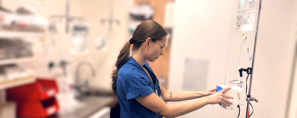 ung kvinna i blå vårdkläder förbereder mediciner på ett sjukhus