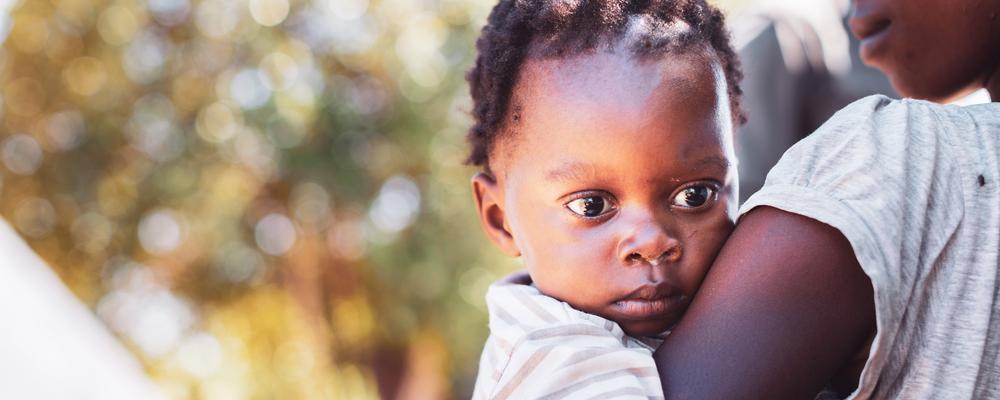 Litet barn i sin mammas famn